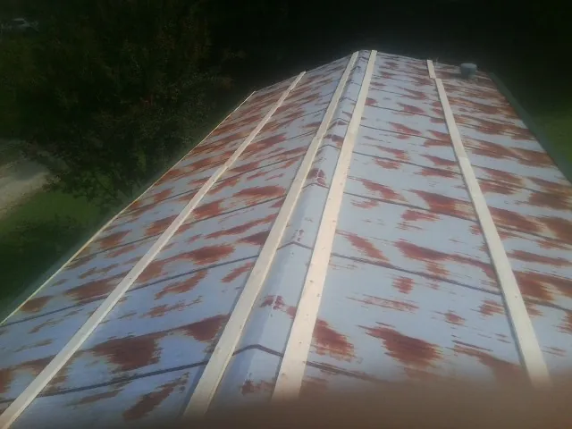 Rusted metal roof panels with new wood purlins before replacement — Storm Damage Roof Repair in Marcy by Roofing Brothers