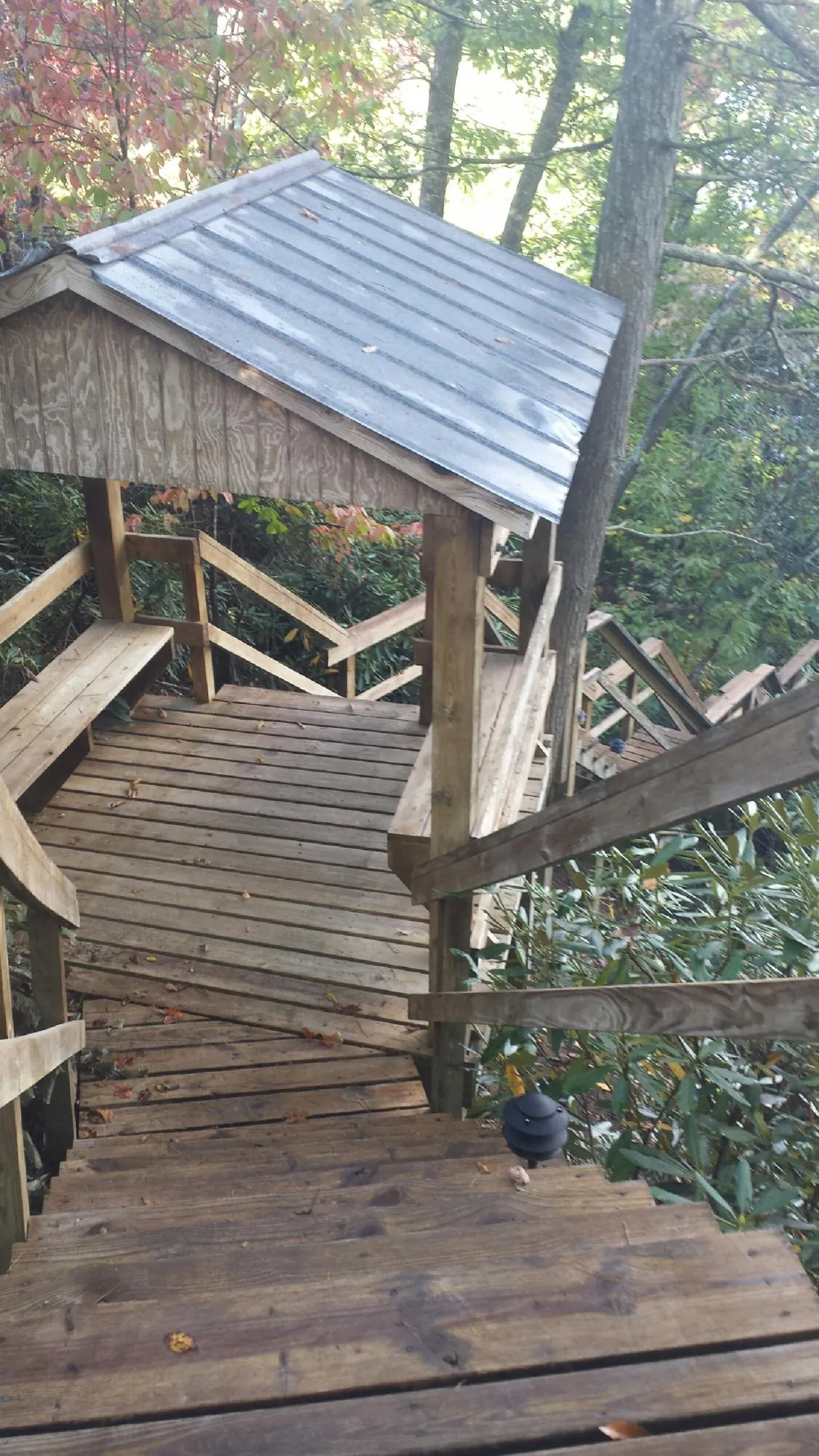 Metal roofed shelter over wooden steps on a wooded walkway — Skylight Repair & Installation work by our crew in Marcy