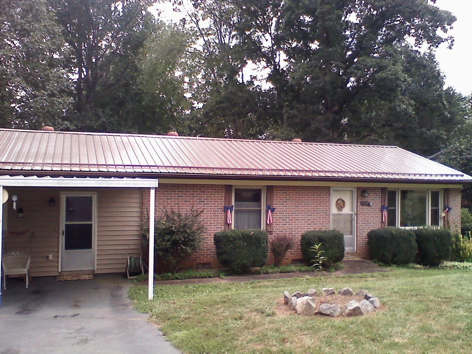Bronze metal roof and carport on a brick ranch home — Roof Repair work by our crew in Marcy